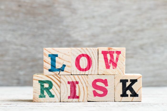 Wooden letter blocks on a table that spell “Low Risk”
