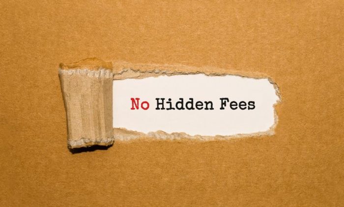 A printed message that reads “No Hidden Fees” behind a layer of torn cardboard